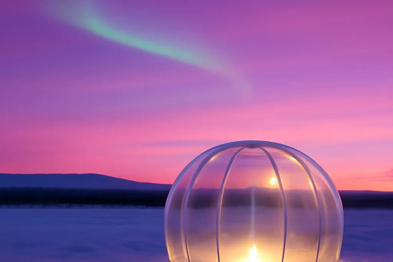 Aurore boréale au-dessus d'un campement d'igloos enneiges en Laponie finlandaise