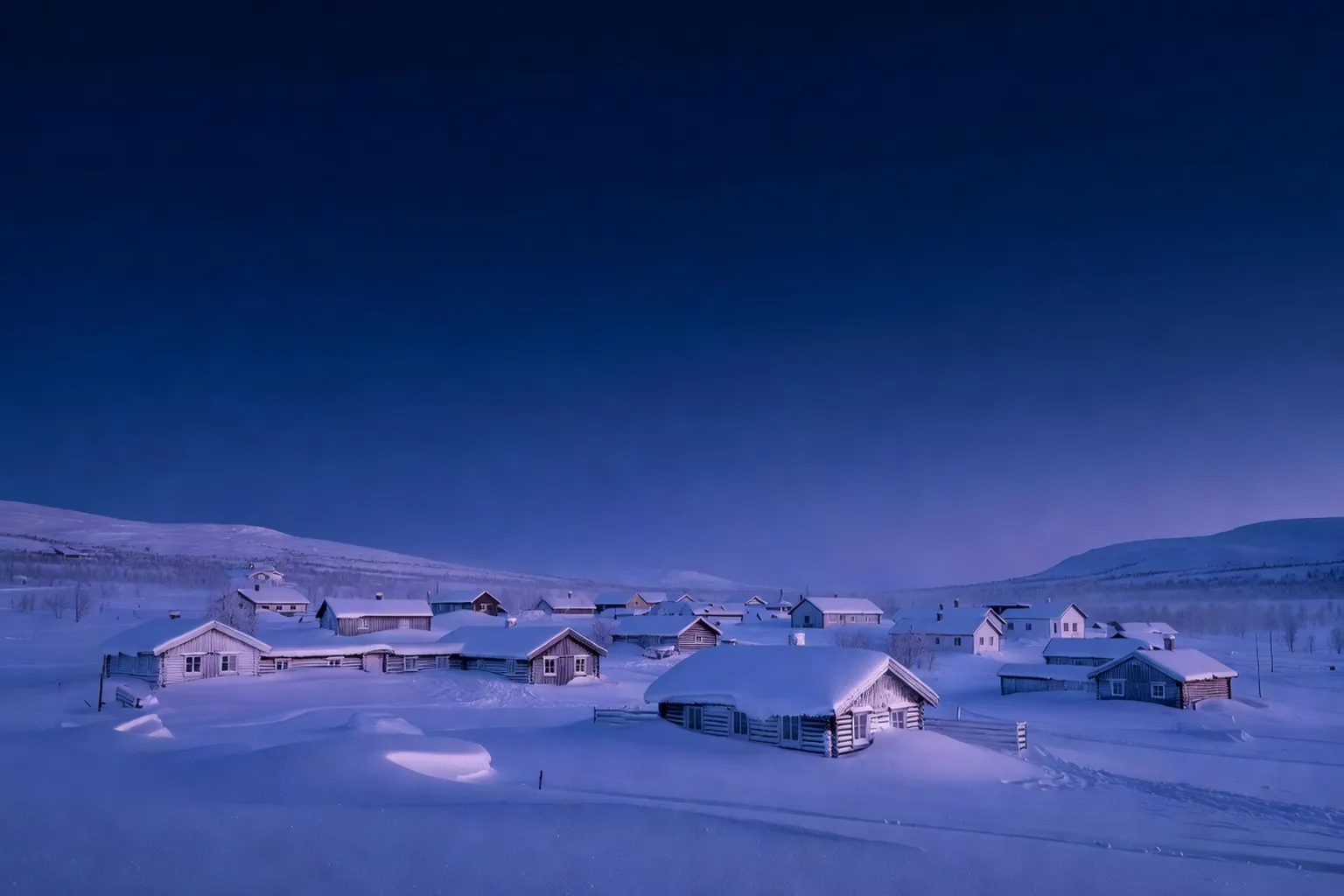 Crépuscule bleu de midi sur le lac gelé de Kilpisjärvi pendant le kaamos, avec une bande orangée à l'horizon sud