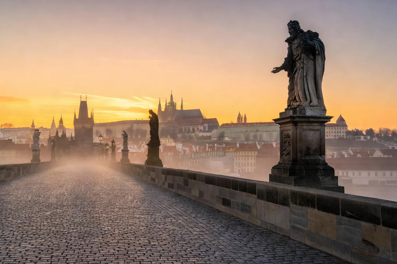 Pont Charles de Prague avec ses statues baroques au lever du jour